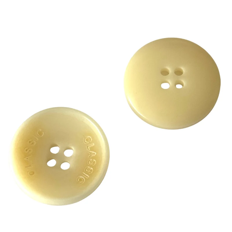 Steinnuss Knopf 15-20 mm creme 4-Loch mit Rand mit klassischem Schrift-Detail